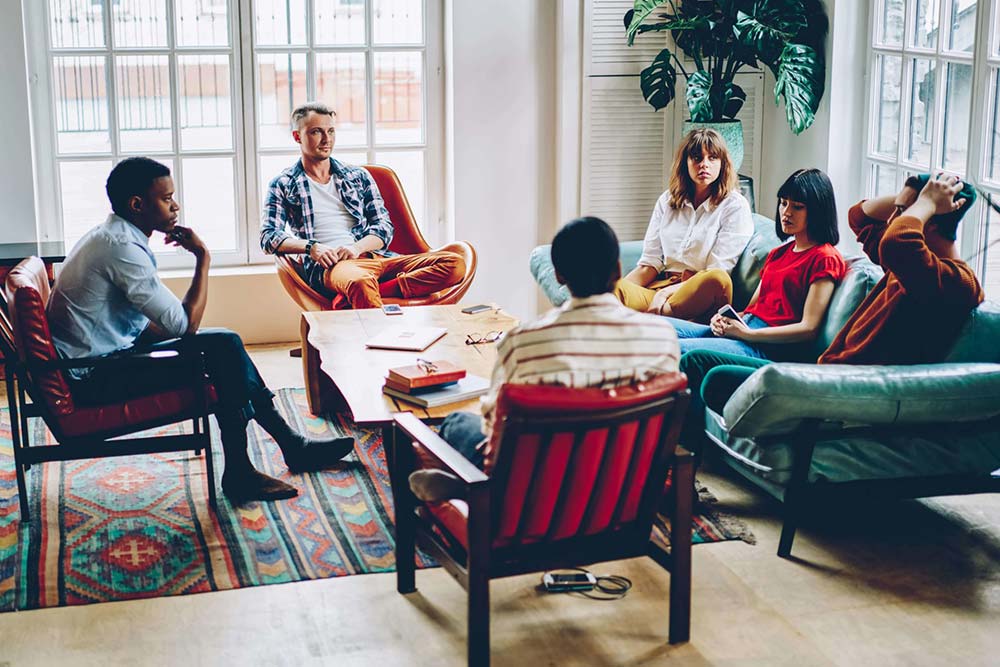 find-sober-living group of men and women showing support to a friend