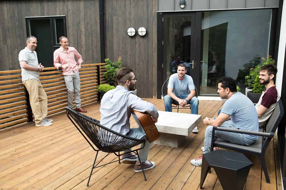 sober-living Group men sitting around a table with a guitar player